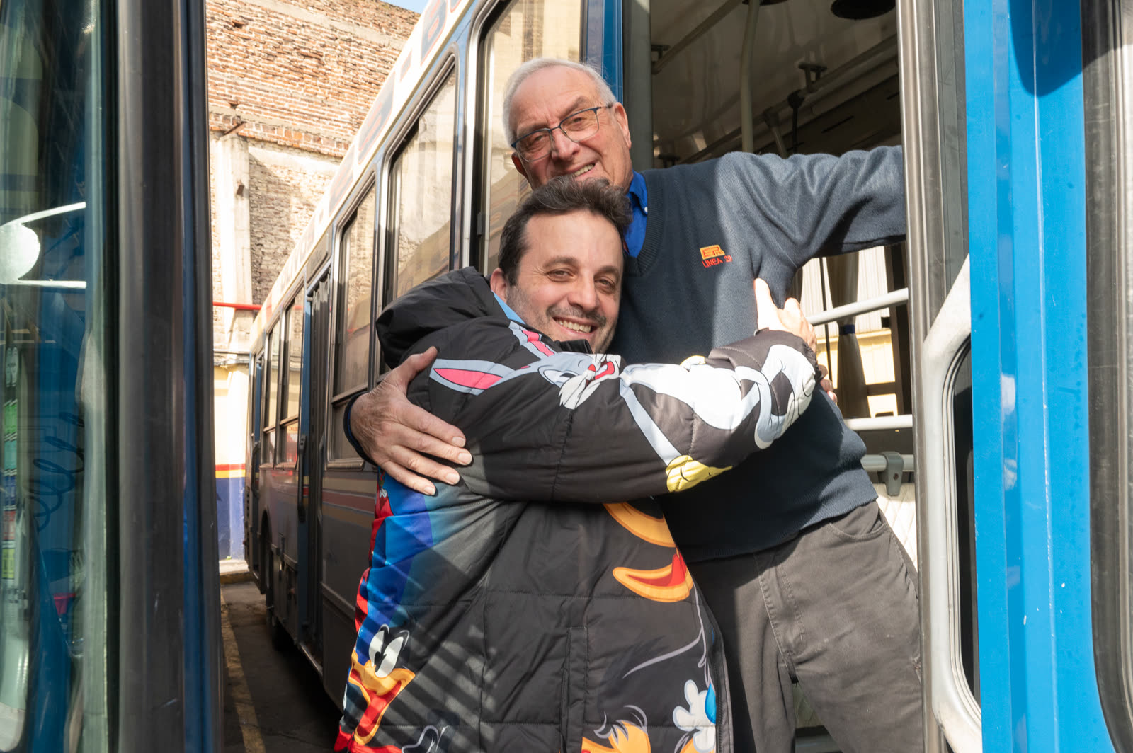 Rodrigo Calabrese abraza a su padre, chofer de la Línea 29, en la puerta de un colectivo